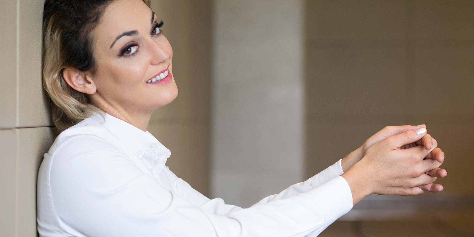 Mujer de edad madura empresaria sonriendo segura de sí misma sentada en el suelo relajada.
