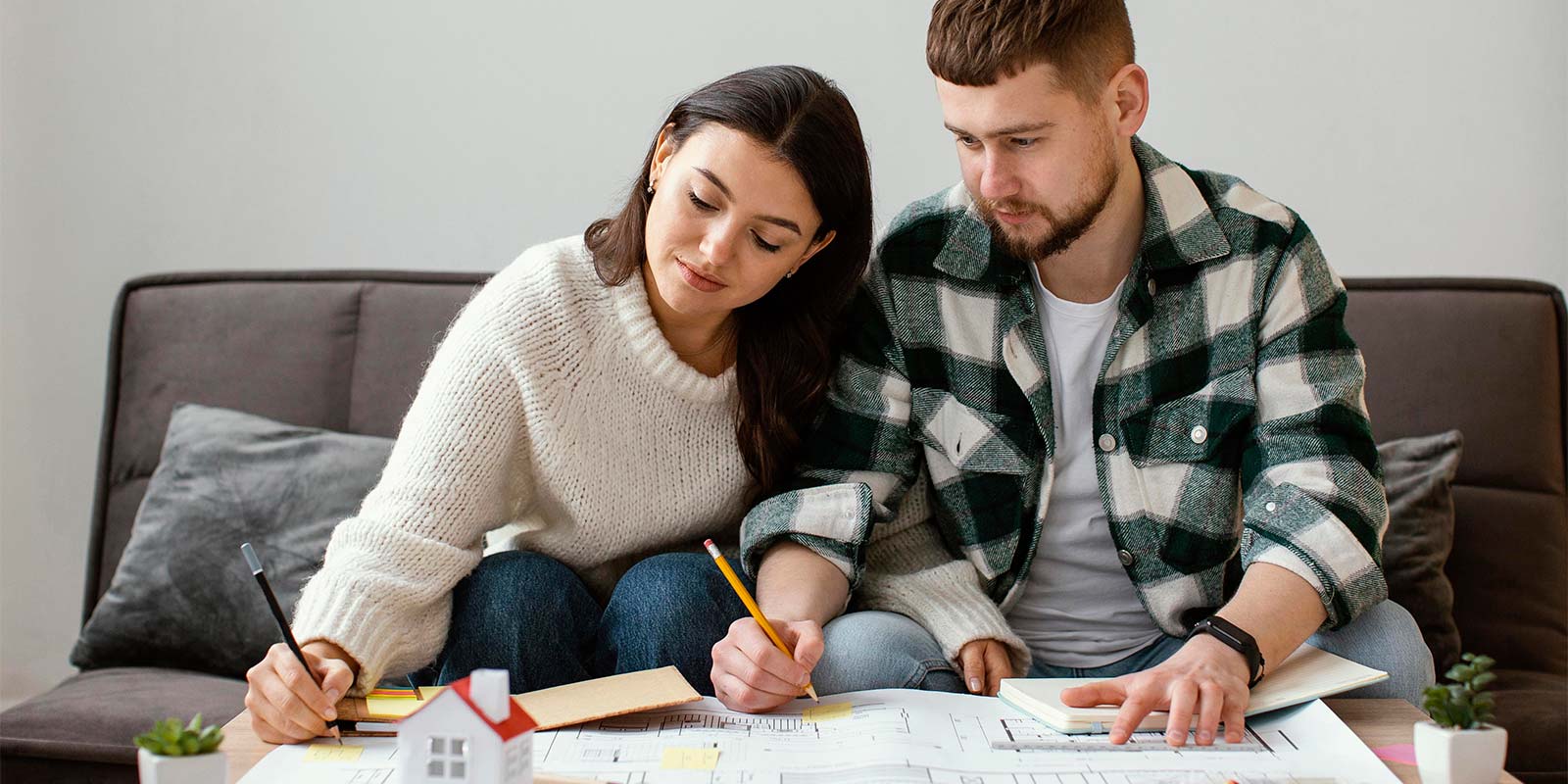 Pareja revisando papeles y haciendo cálculos para tener en cuenta la rentabilidad.