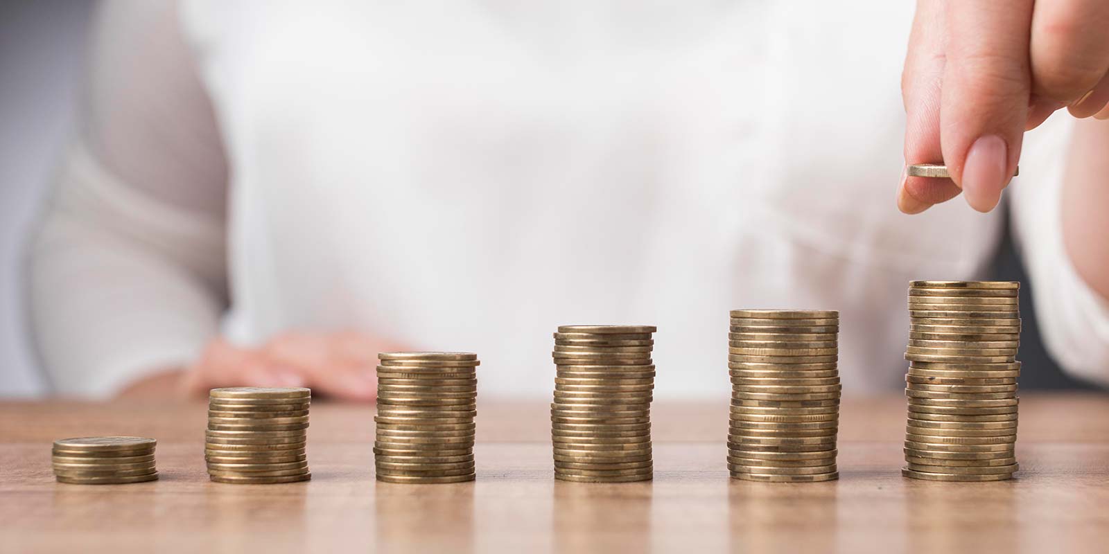 Imagen de una persona haciendo pilas de monedas en concepto de inversión y revalorización.