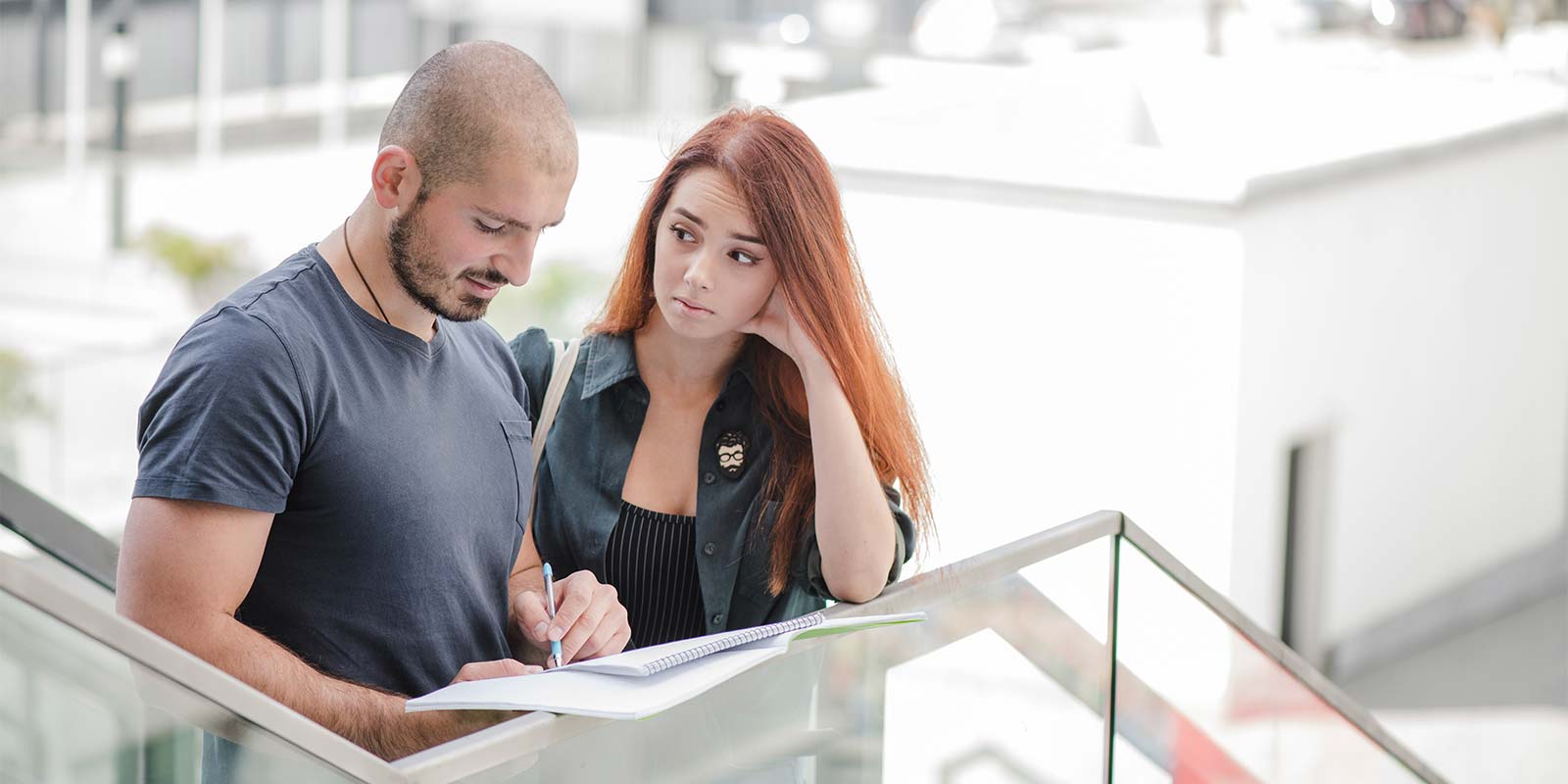 Pareja de hombre y mujer, donde el hombre está firmando documentación y la mujer lo mira dudando. Cuestiones que suceden a la hora de elegir una inmobiliaria (o no) con la que trabajar. Gisela puede orientarte sin ningún tipo de obligación. La decisión es tuya.