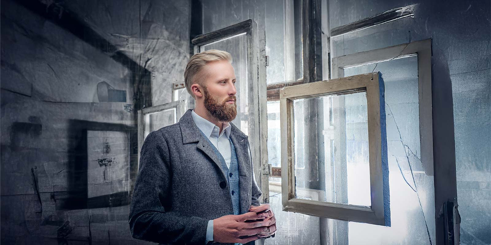 Hombre joven en un cuarto frío con marcos y ventanas. En representación de inversor de origen nórdico de Europa para realizar inversiones inmobiliarias real estate en la Costa del Sol a largo o corto plazo.