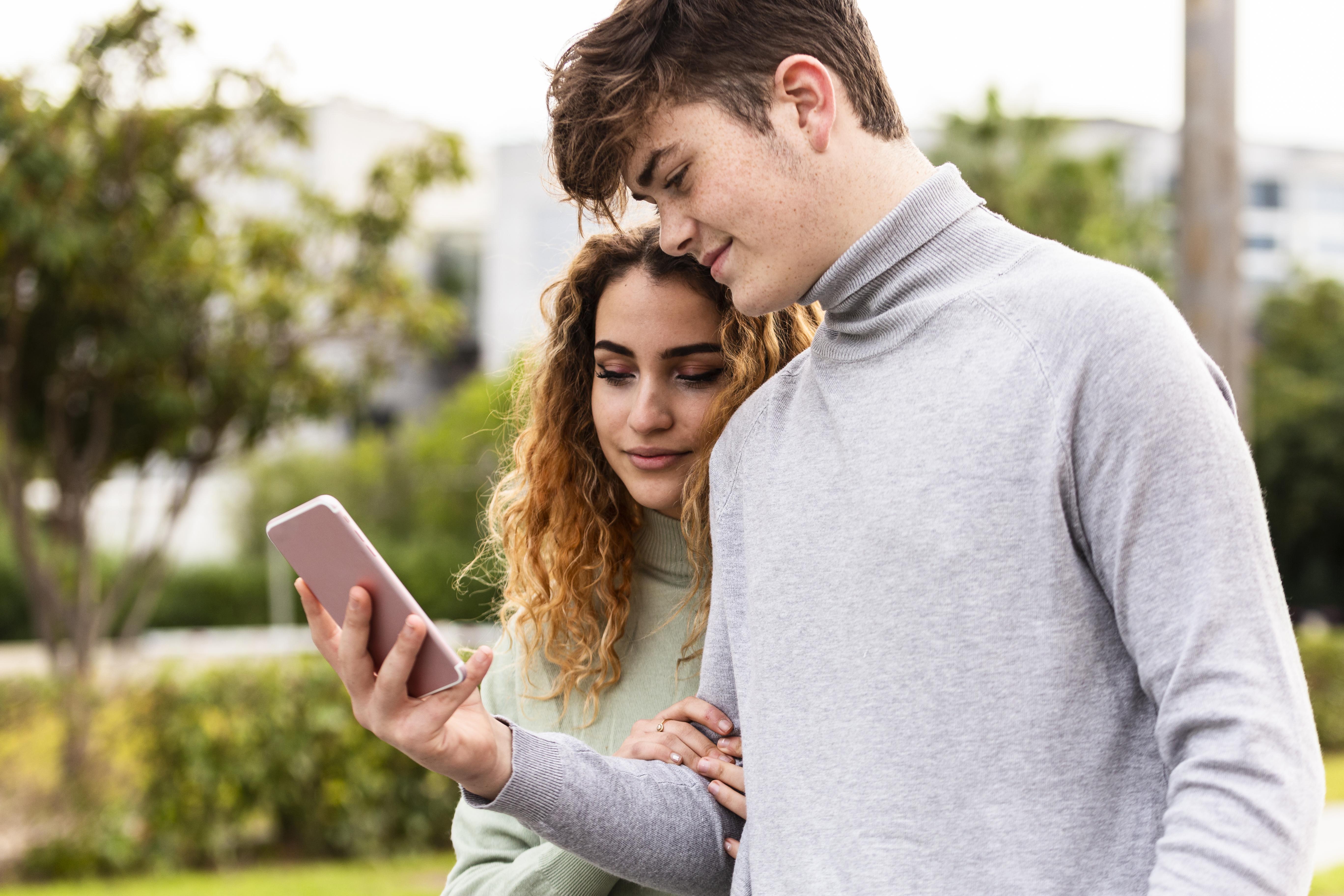 Pareja mirando el móvil. En referencia a la búsqueda de inmuebles en internet y portales a través de los dispositivos, y de ahí su relevancia a tener una buena red y estrategia de marketing en redes sociales, webs y portales.
